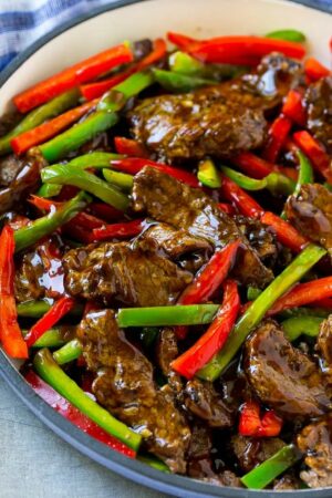 Pepper steak stir fry with thinly sliced steak and red and green bell peppers in a savory sauce. | Pepper steak, Stir fry dinners, Steak dishes