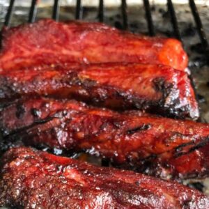 Jeff Mauro on Instagram: “Smoked about 50 of these super tasty Chinese Takeout-style Spare Ribs. Dropped off most to my folks and in-laws and devoured  the other dozen for dinner. Super easy. Super RED. Recipe below!
*

2 racks of spare ribs (St. Louis Style works best), individually slice into single ribs
¼ cup soy sauce
½ cup hoisin’
3 tablespoons Chinese rice wine
2 tablespoons dark brown sugar
2 tablespoons honey
1 tablespoons five-spice powder
1 teaspoon granulated garlic
1 teaspoon fresh, zested ginger
1 teaspoon red food coloring
Toasted sesame seeds
Scallion greens, sliced very thin on the bias 
Mix all ingredients in a metal, non-reactive bowl.  Pour majority of the marinade into a large zipper bag, reserve about ½ cup for basting later.  Place ribs in bag and marinate over night if possible, but at least 3 hours. Remove and place individual ribs on a wire rack. 
Set grill to 275 and place rack directly on to cooler side of the grill.  Cook for 2-3 hours or until very tender, basting 3 times during the cook.  Remove from grill, increase the heat to high.  Drizzle the ribs with a bit of extra honey and on the super hot grill, quickly char each rib until caramelized. 
Garnish with sesame seeds and scallion greens.”