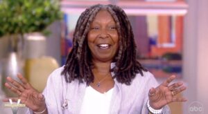 Whoopi Goldberg Greeted With Standing Ovation Upon Post-Covid Return To ‘The View’ Sporting Folding Chair Necklace